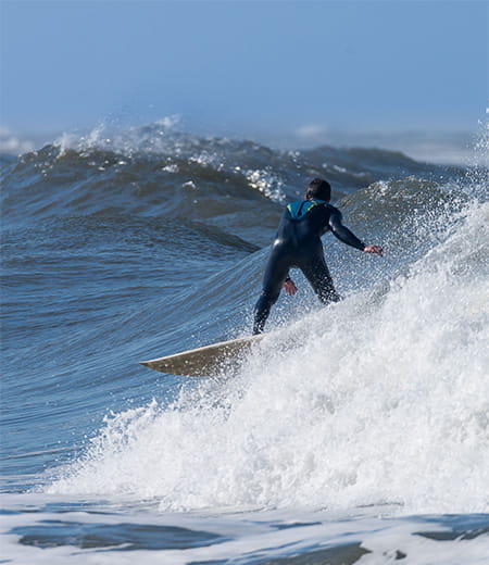Surfista a preparar-se para uma manobra nas ondas. Mental coaching para atletas de desportos radicais.